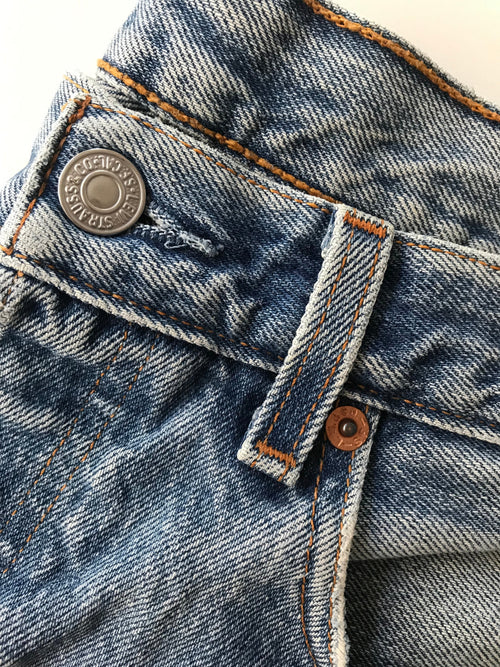 A close up of a vintage levis button