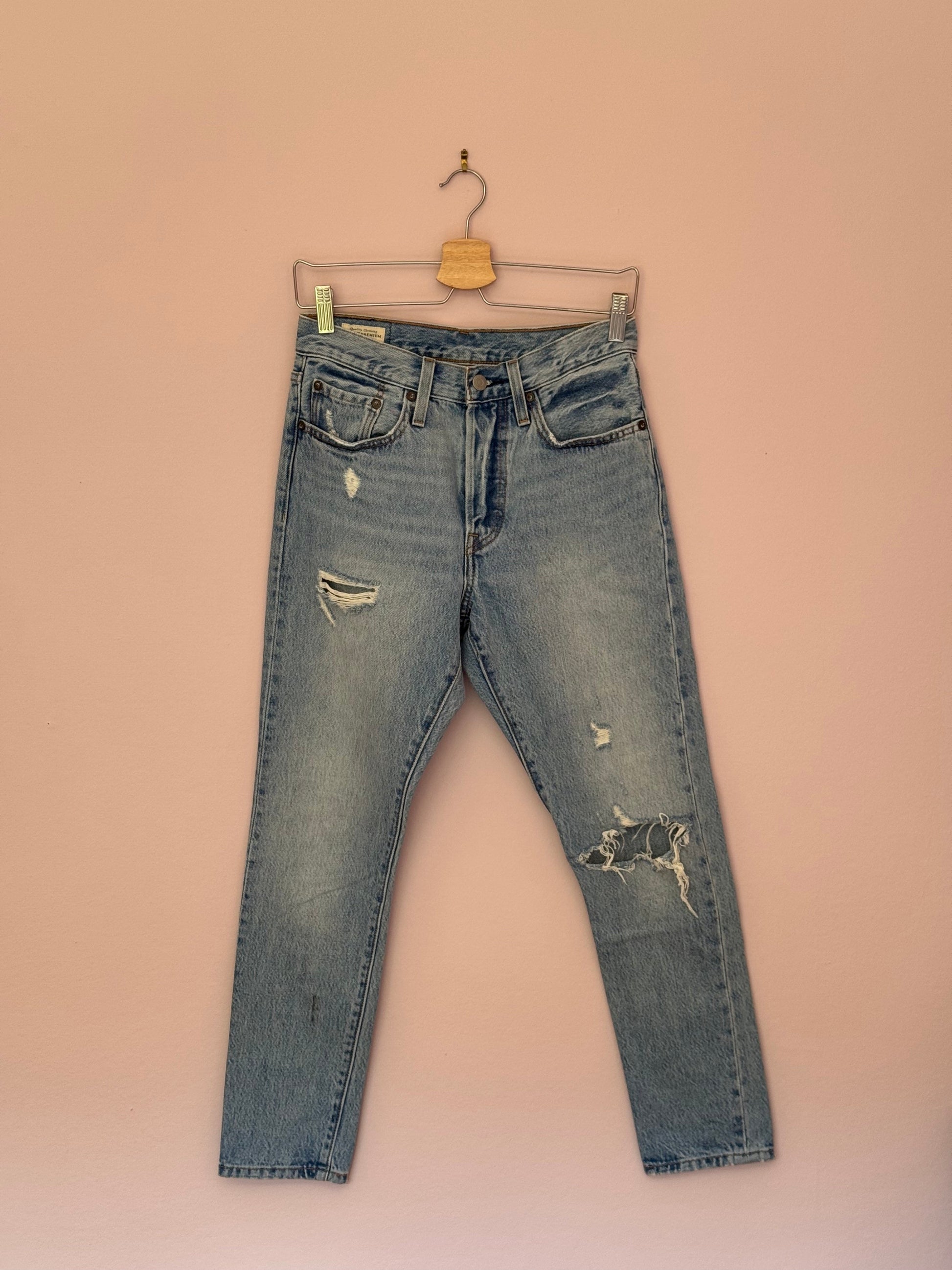 Distressed blue jeans on a beige background
