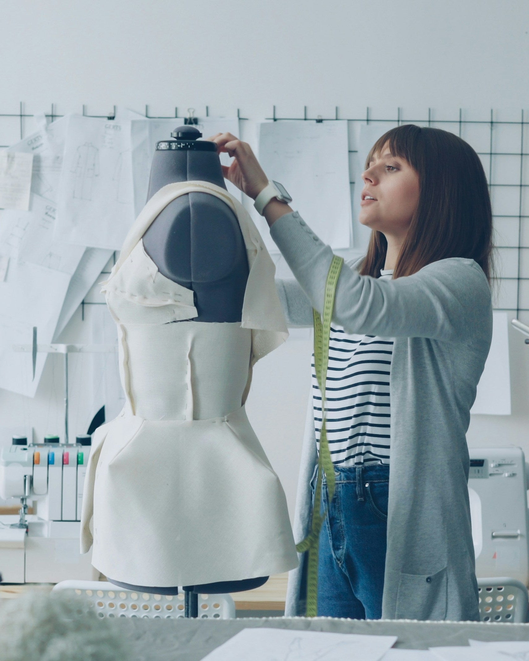 Two women working on a mannequin in a design studio.